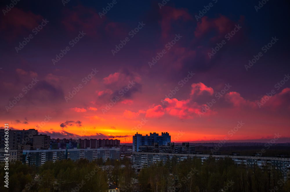 Colourful sunset of cloudy sky with orange and blue colors over the old buildings in Russia. Beautiful skyscape in the city