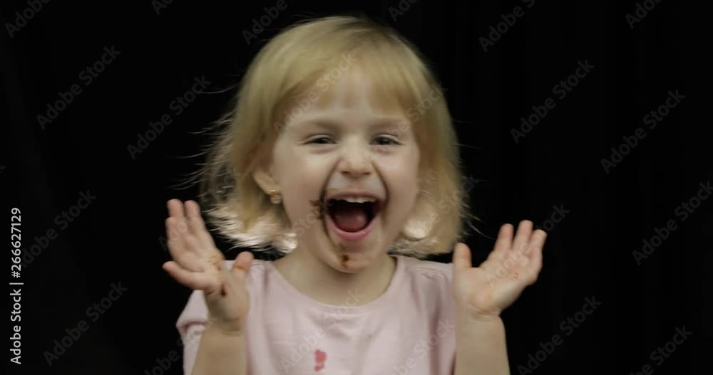 Child with dirty face from melted chocolate and whipped cream smiling Child with dirty face from melted chocolate and whipped cream smiling