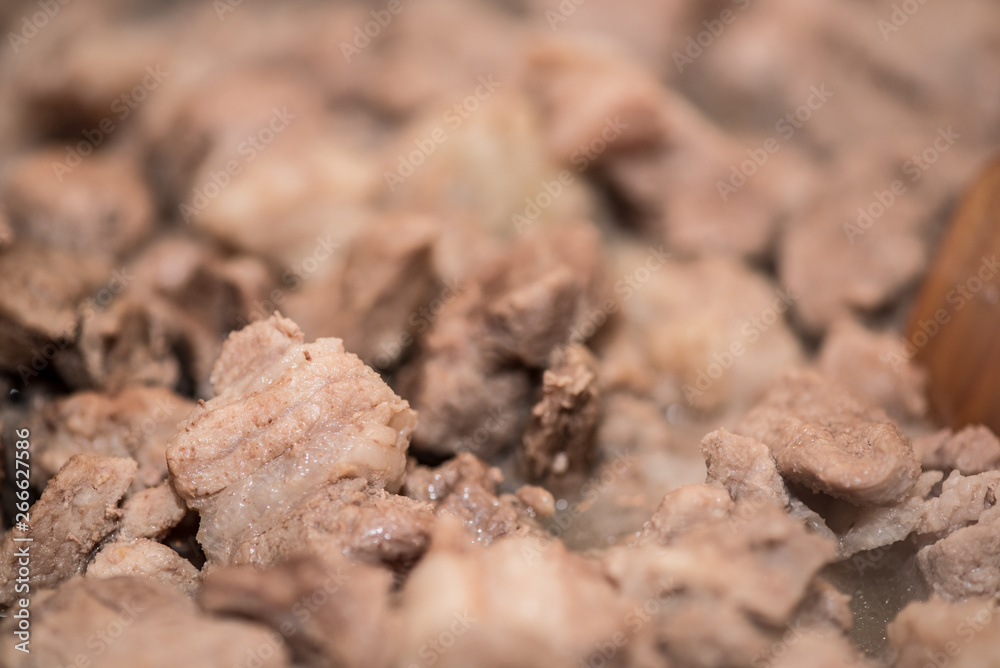 Home-made pork stew in pan. Cooking process close-up