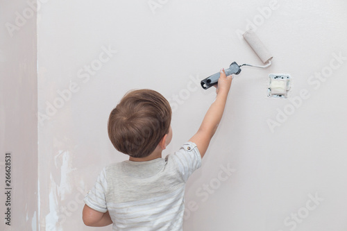 3 years cute little boy with paint roller in hand