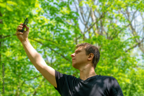 Obraz na płótnie Man with his mobile smart phone searching for reception signal in the forest. w salonie