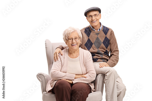 Elderly couple sitting in an armchair and looking at the camera © Ljupco Smokovski