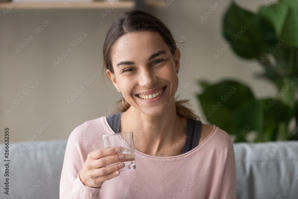 Headshot healthy woman sit on couch holding glass of water Headshot healthy woman sit on couch holding glass of water