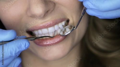 Pretty woman's teeth examining in dental clinic