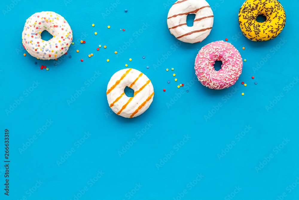Naklejka premium Modern design with bright donuts on blue background top view mock up