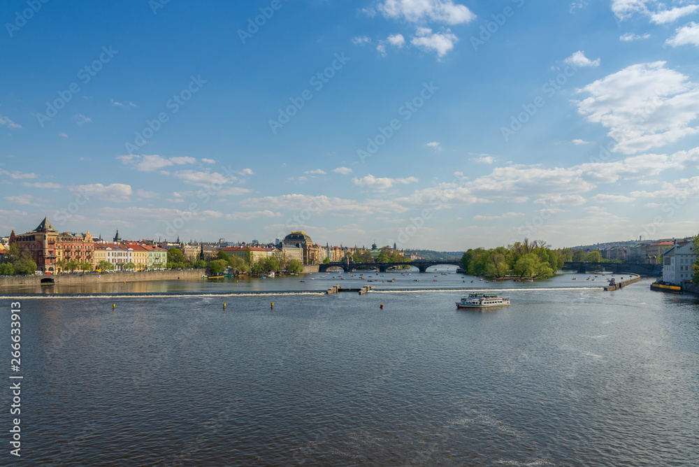 Outdoor sunny scenery of Vltava river and riverside from Karlův most, Charles Bridge, and background of Most Legií,  Legions Bridge, and National Theatre, and Museum Kampa in Prague, Czech Republic.