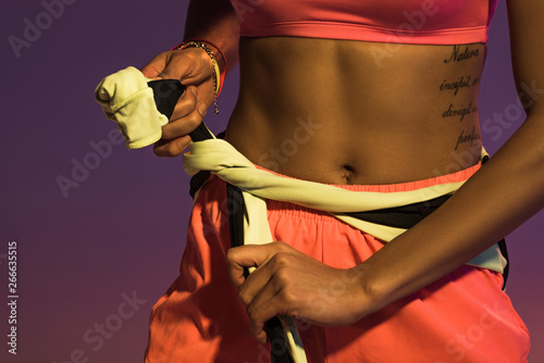 partial view of tattooed african american girl on purple background