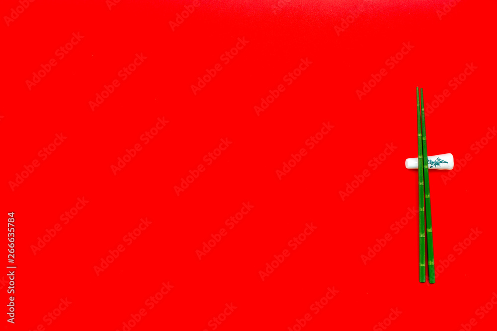 oriental table set up with bamboo sticks on red background top view space for text oriental table set up with bamboo sticks on red background top view space for text