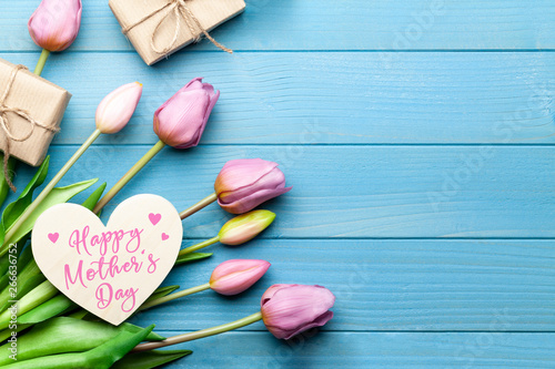 Happy mothers day with tulips, heart and gifts blue wooden background