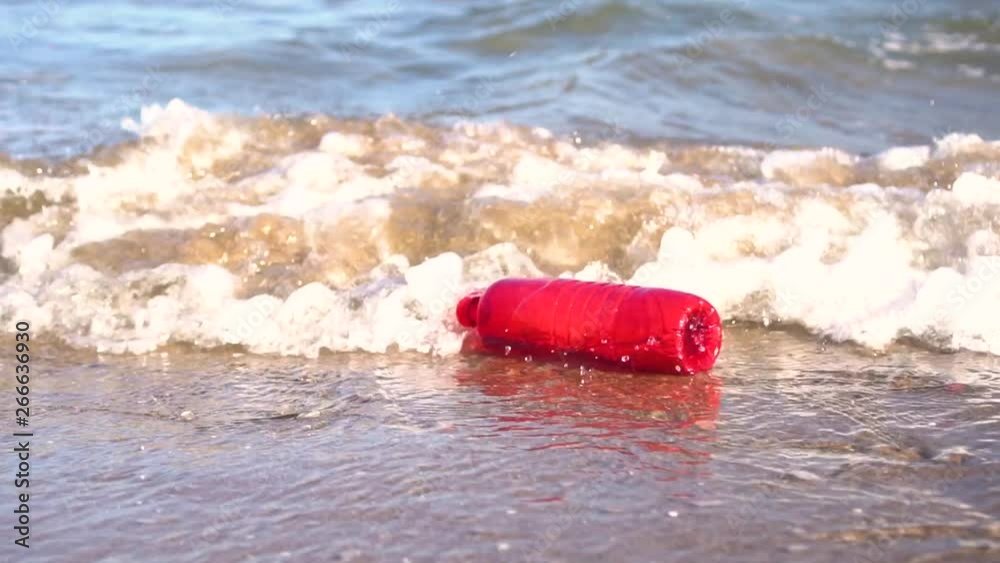 120fps: Red plastic bottle drift in water. Waste getting thrown on the beach by the waves. Sea Ocean pollution concept. 120fps: Red plastic bottle drift in water. Waste getting thrown on the beach by the waves. Sea Ocean pollution concept.