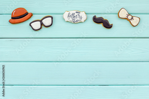 Happy Father Day with bow tie, moustache, glasses and hat cookies on mint green wooden background top view mockup