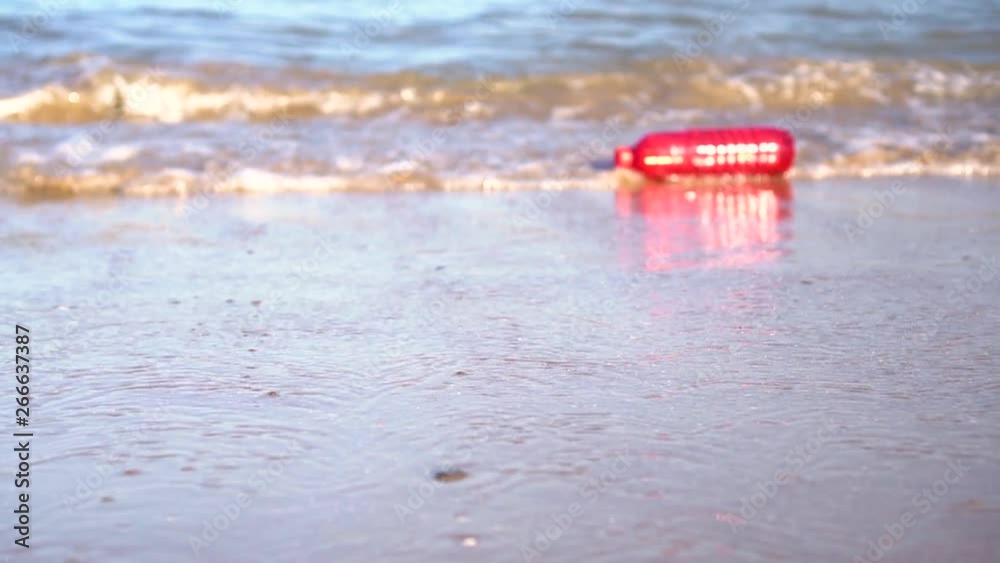 120fps: Red plastic bottle drift in water. Waste getting thrown on the beach by the waves. Sea Ocean pollution concept. 120fps: Red plastic bottle drift in water. Waste getting thrown on the beach by the waves. Sea Ocean pollution concept.