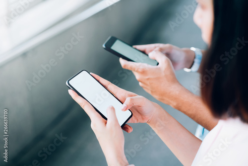 woman and man  holding a smartphone  mock up of blank screen. using cell phone on lifestyle. Technology for communication concept.
