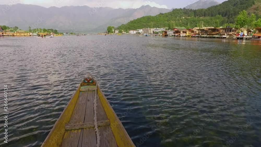 Handheld, exterior shot from a boat as it slowly cruises on a river with homes and a mountain in the background. Handheld, exterior shot from a boat as it slowly cruises on a river with homes and a mountain in the background.