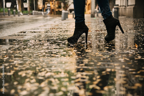 Woman walking on the sidewalk after the rain