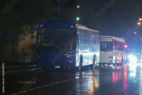 buses on the street at night in the rain