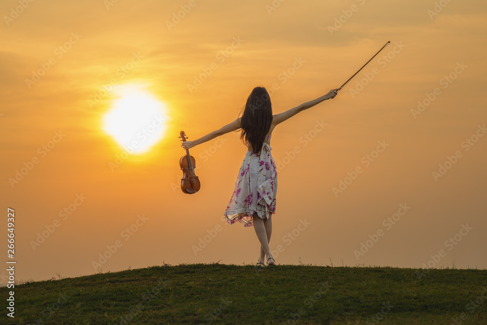 Beautiful woman enjoying music at sunset