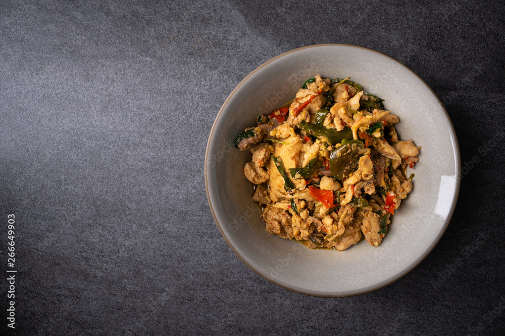 Fried stir basil with chicken internal organs in gray bowl on concrete table. Fried stir basil with chicken internal organs in gray bowl on concrete table.