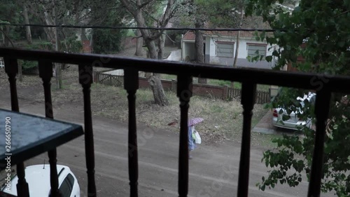 pan shot from the balcony of the rain with people passing by photo