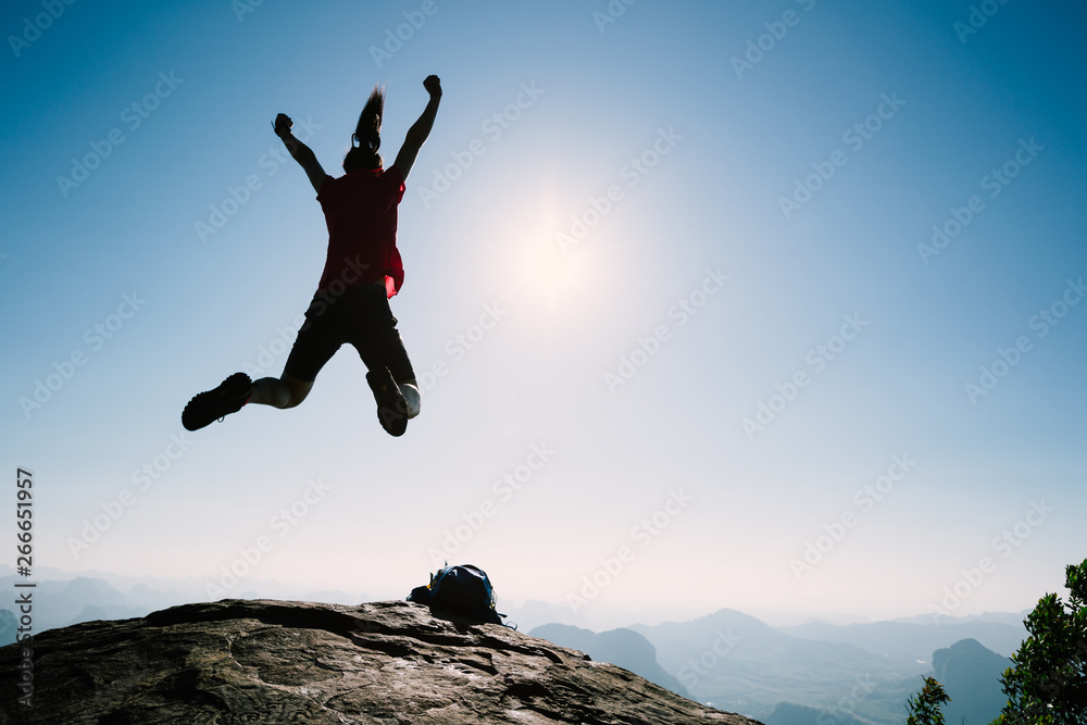 succesful woman hiker jumping on sunrise mountain top succesful woman hiker jumping on sunrise mountain top
