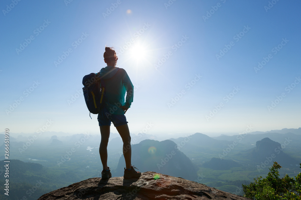 Obraz premium Successful woman hiker enjoy the beautiful landscape in the sunrise mountain peak cliff edge