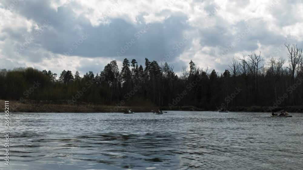 People paddle along the river in cloudy weather. People paddle along the river in cloudy weather.