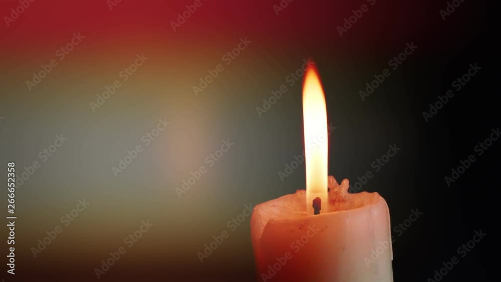The showcases of colorful single candlelight on black background with the effect of light and slow motion.