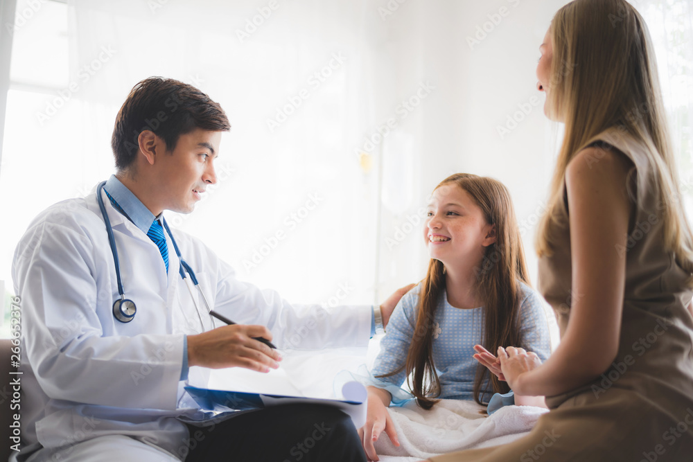 Fototapeta premium The handsome doctor is examining the symptoms of a girl together with her mother. And to schedule an appointment.