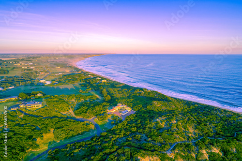 Luxury homes on ocean coastline at sunset - aerial view © Greg Brave