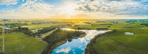 Panel kuchenny z motywem Sun setting over scenic Australian countryside grasslands and pastures with river passing through - aerial panorama