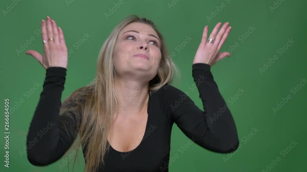Portrait of young businesswoman in black blouse laughing and talking actively with camera at green background. Portrait of young businesswoman in black blouse laughing and talking actively with camera at green background.