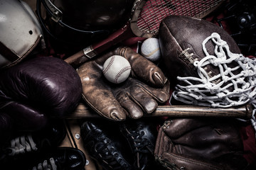 A large group of assorted vintage antique sports equipment. Including football helmet, baseball and boxing gloves etc.