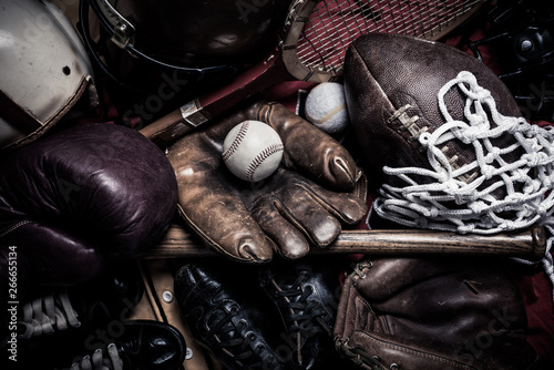 A large group of assorted vintage antique sports equipment. Including football helmet, baseball and boxing gloves etc. © jaflippo