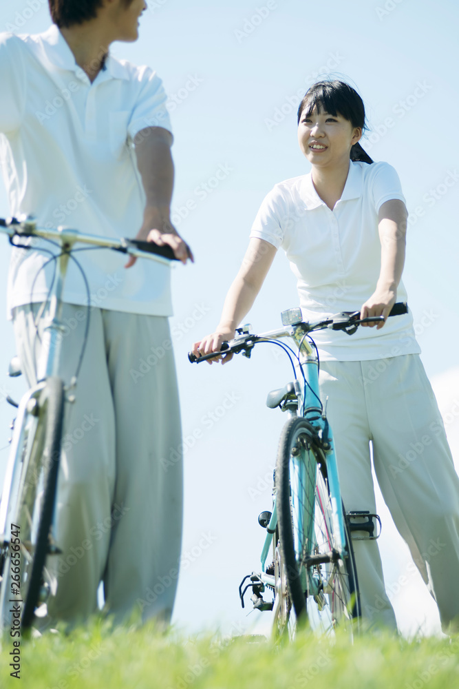 Obraz premium 草原で自転車を押すカップル