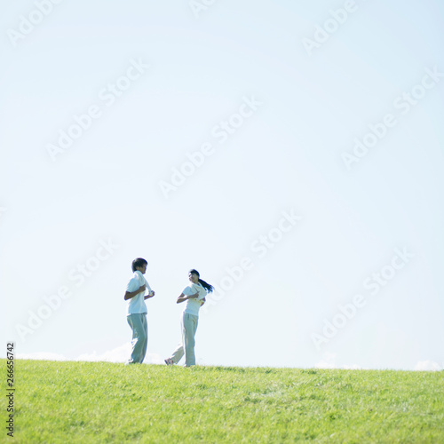 草原でジョギングをするカップル
