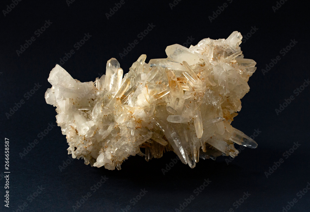 Scolecite mineral sample. White yellowish cluster of crystals in black background. Scolecite is a tectosilicate mineral belonging to the zeolite group. Scolecite mineral sample. White yellowish cluster of crystals in black background. Scolecite is a tectosilicate mineral belonging to the zeolite group.