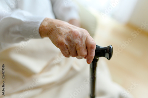 Rentnerin stützt sich auf einen Gehstock