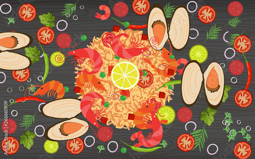 paella and vegetables on the black wooden table