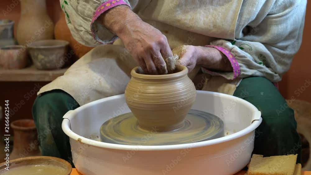 Creating vase of white clay close-up. The sculptor in workshop makes jug out of clay closeup. Twisted potter's wheel. Master crock. Creating vase of white clay close-up. The sculptor in workshop makes jug out of clay closeup. Twisted potter's wheel. Master crock.