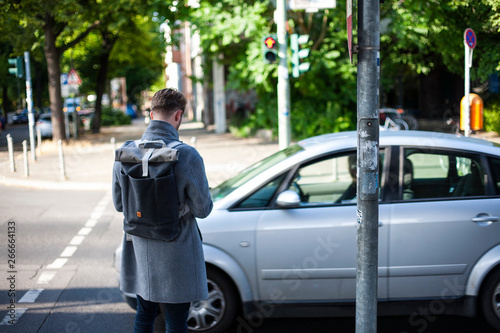 Young man pedestrian with smartphone standing on crosswalk © vanzyst