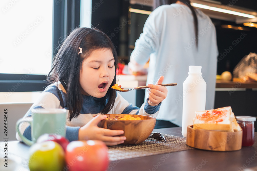 Asian girl kid having breakfast cereal at home kitchen Asian girl kid having breakfast cereal at home kitchen
