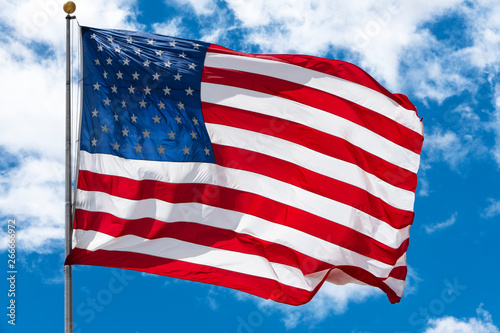 American flag closeup with clouds and blue skies