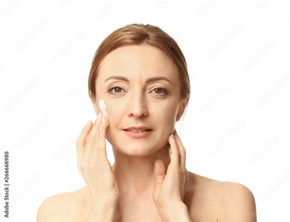 Mature woman applying cream on white background Mature woman applying cream on white background
