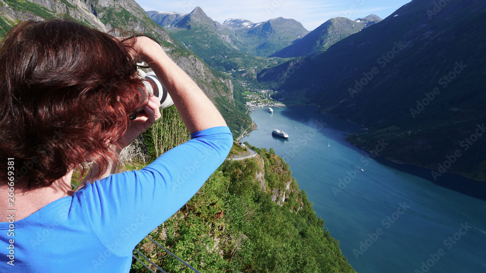 Tourist taking photo of fjord landscape, Norway