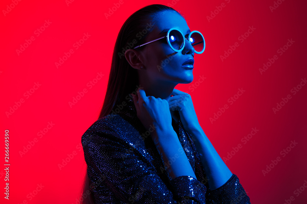 Φωτογραφία Fashion girl with long hair and round sunglasses in a black shining dress poses
