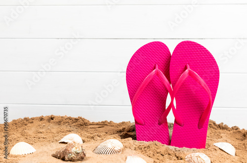 flip flops with shellfish and sand for summetime with copy space photo