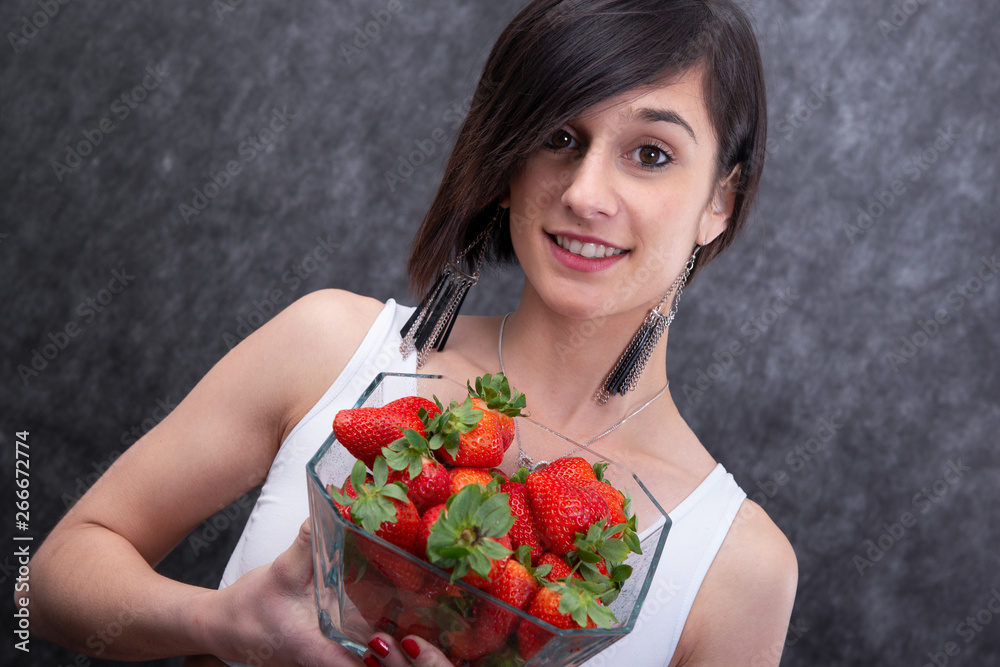 pretty young brunette woman eating strawberry