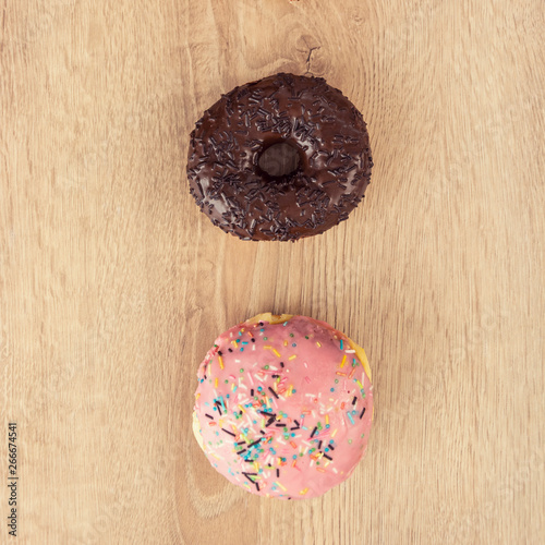 two tasty donuts on wooden table quadrat