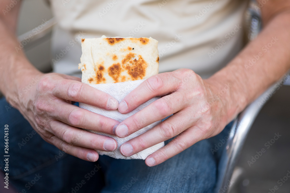 man holding a piadina, wrap, in his hands