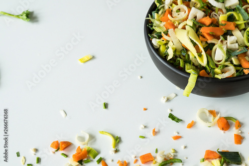 soup  or wok vegetables, ingredients, in black bowl. White background, space for text
